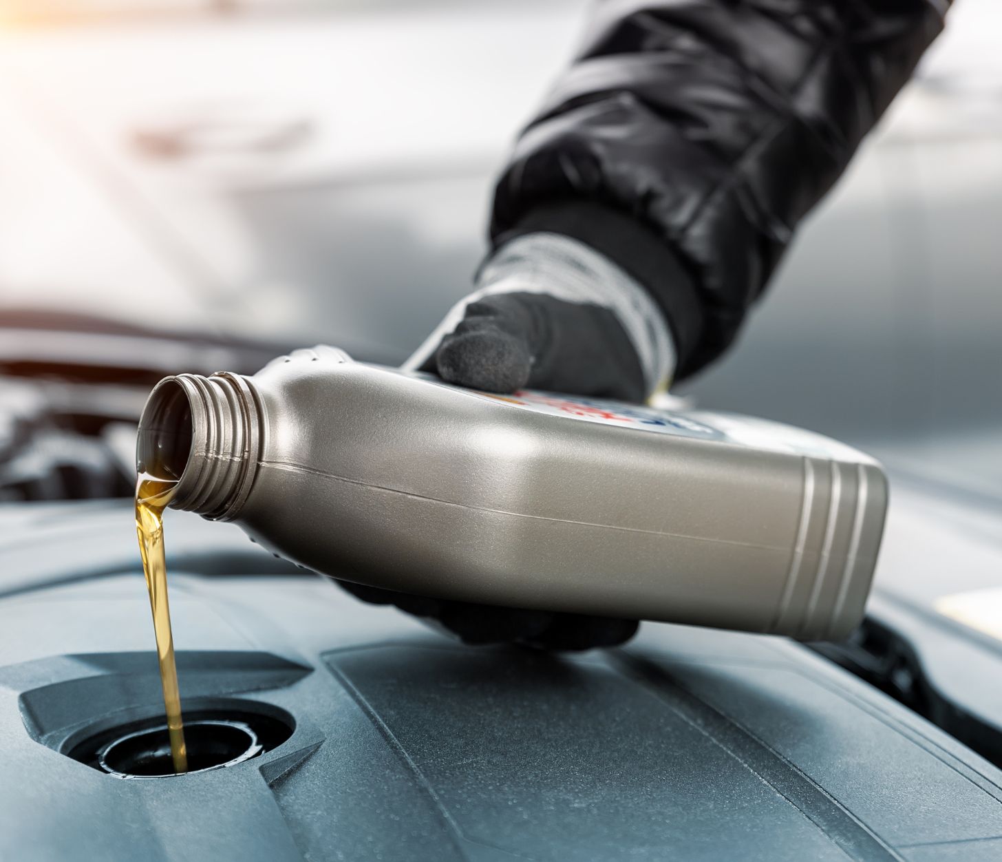 Hand giet motorolie in motor van auto